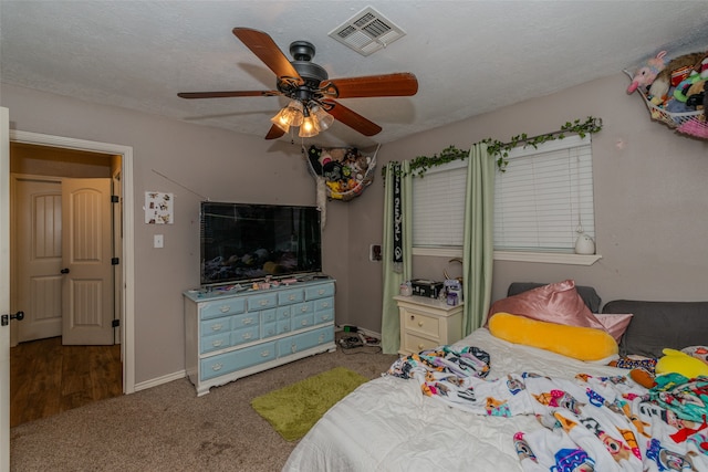 carpeted bedroom with a textured ceiling and ceiling fan