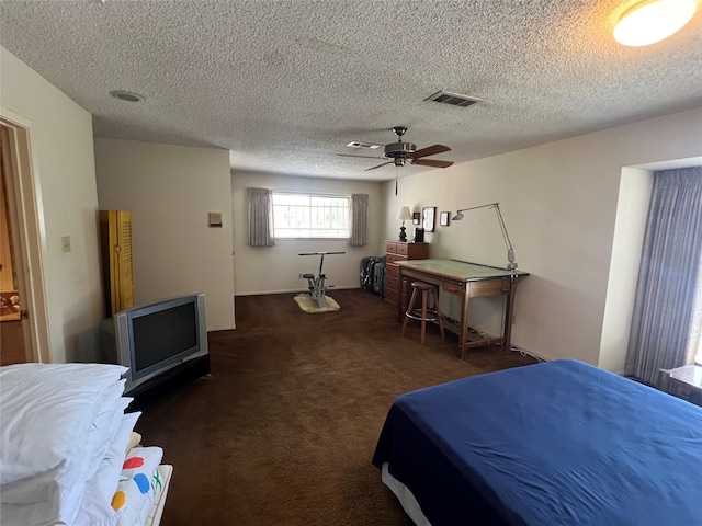 bedroom featuring ceiling fan, a textured ceiling, and dark carpet