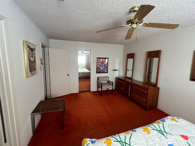 bedroom featuring carpet flooring, a textured ceiling, and ceiling fan