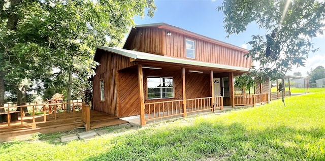 exterior space featuring a wooden deck and a front yard