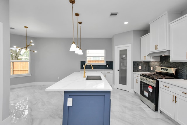 kitchen with backsplash, a notable chandelier, sink, a kitchen island with sink, and stainless steel gas range oven