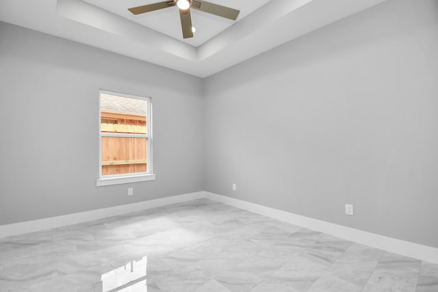 unfurnished room with a raised ceiling and ceiling fan