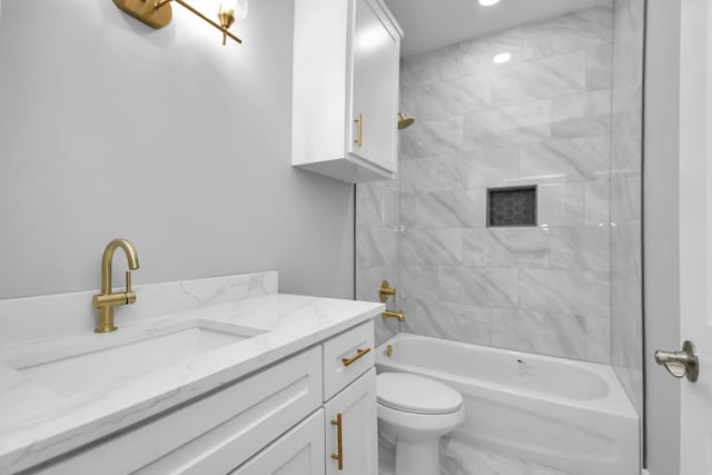 full bathroom featuring tiled shower / bath combo, vanity, and toilet