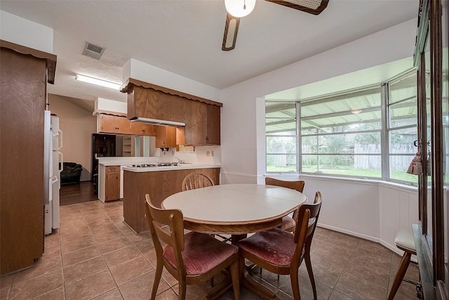 tiled dining room with a textured ceiling, ceiling fan, and lofted ceiling