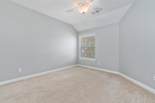 spare room featuring ceiling fan, vaulted ceiling, and light carpet