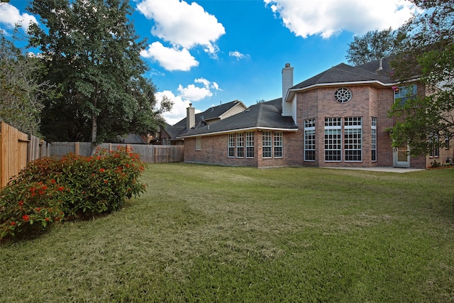 back of property with a lawn