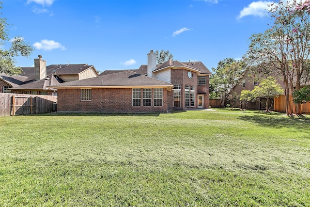 rear view of property featuring a lawn