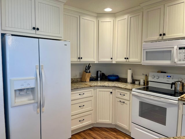 kitchen featuring white appliances, light stone countertops, and light hardwood / wood-style flooring