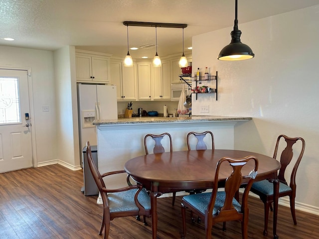 dining room featuring dark hardwood / wood-style floors and a textured ceiling