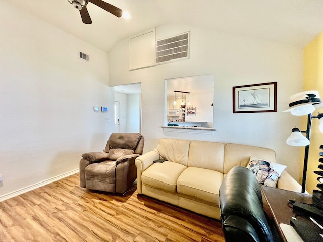 living room featuring ceiling fan, high vaulted ceiling, and light hardwood / wood-style flooring