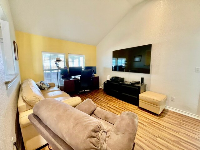 living room featuring high vaulted ceiling and light wood-type flooring