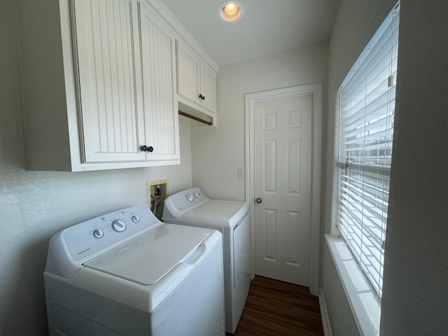 clothes washing area featuring cabinets, washing machine and dryer, and dark hardwood / wood-style flooring