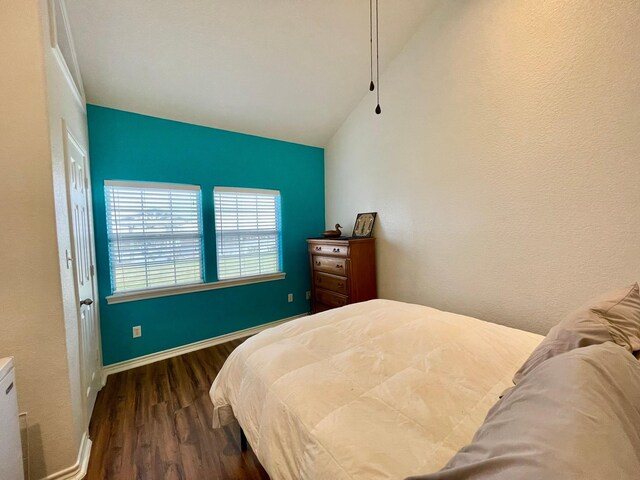 bedroom with lofted ceiling and dark hardwood / wood-style flooring