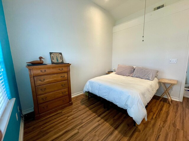 bedroom with dark wood-type flooring, visible vents, and baseboards