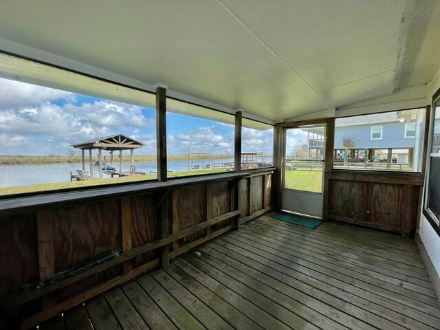 unfurnished sunroom featuring a water view and vaulted ceiling