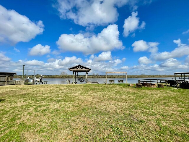 view of dock featuring a water view and a lawn