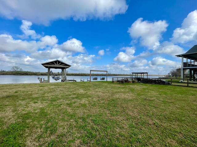 dock area with a lawn and a water view