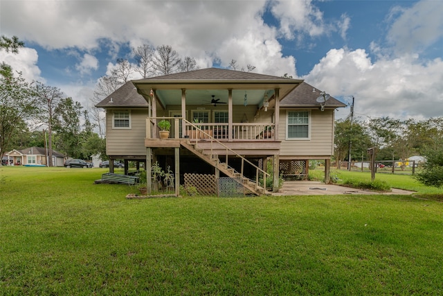 rear view of house featuring a lawn and ceiling fan