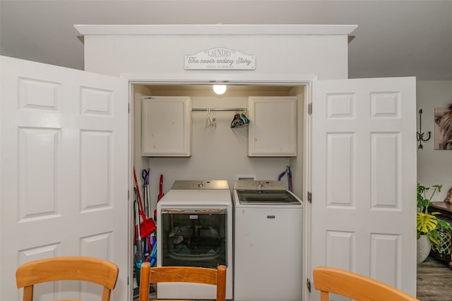 laundry area with hardwood / wood-style floors, cabinets, and washer and dryer