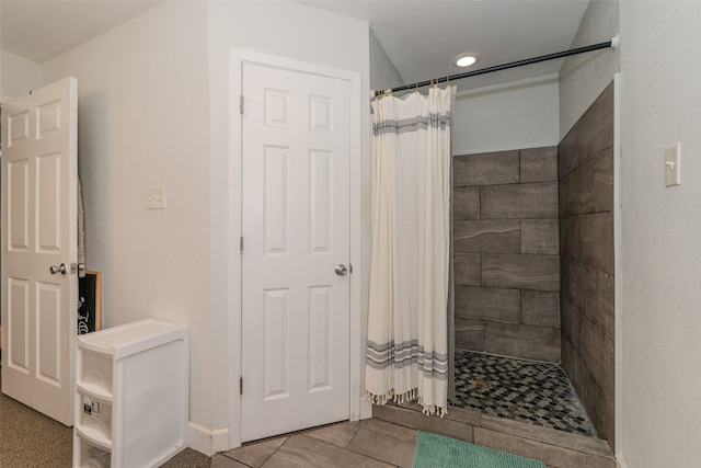 bathroom with a shower with shower curtain and tile patterned floors