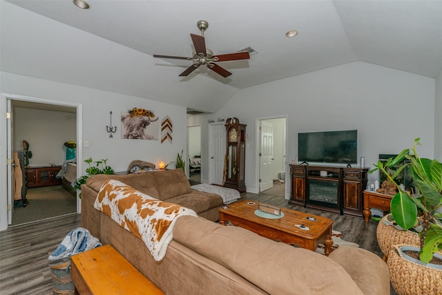 living room featuring ceiling fan, dark hardwood / wood-style floors, vaulted ceiling, and a fireplace