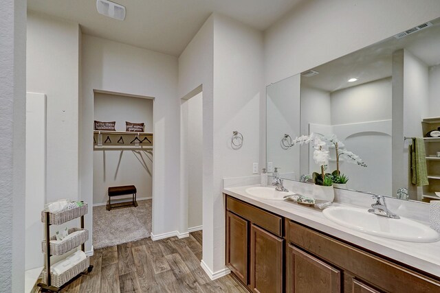 14242 W Pine Heart Dr, Conroe, TX 77302 - bathroom with double vanity, wood finished floors, and a walk in closet