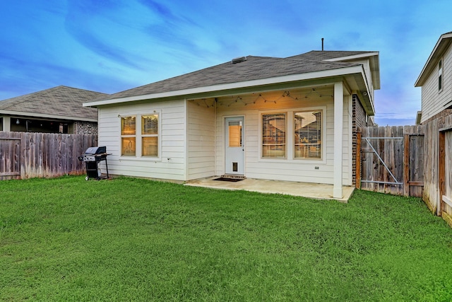 rear view of house with ceiling fan, a lawn, and a patio area