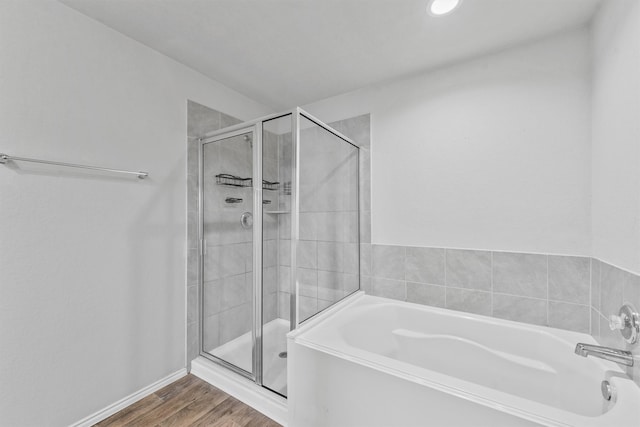 bathroom featuring independent shower and bath and hardwood / wood-style flooring