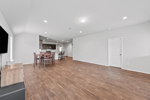 living room featuring hardwood / wood-style floors and vaulted ceiling