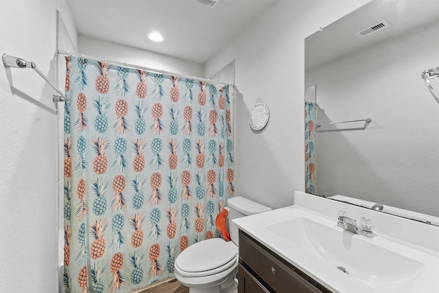 bathroom featuring vanity, toilet, and walk in shower