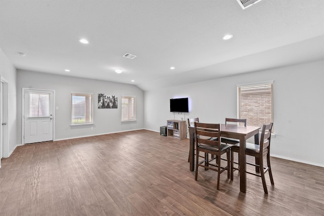 dining room with a textured ceiling, dark hardwood / wood-style flooring, and lofted ceiling