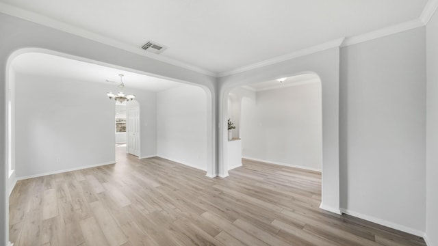 unfurnished room featuring an inviting chandelier, light hardwood / wood-style flooring, and crown molding