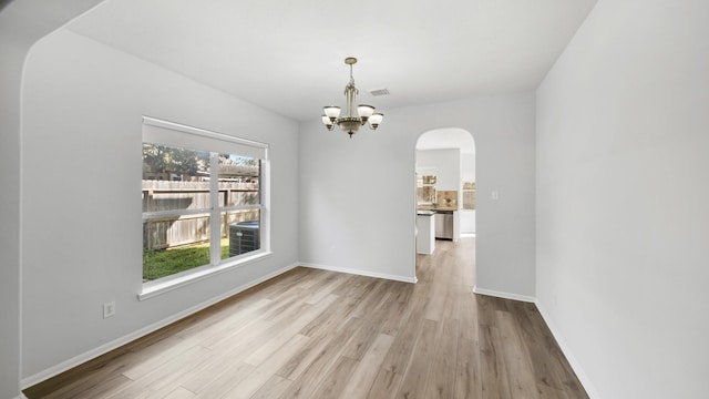 unfurnished dining area with a chandelier and light hardwood / wood-style floors