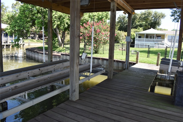 dock area with a lawn and a water view