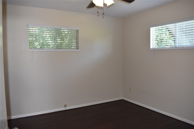 empty room with ceiling fan, dark hardwood / wood-style floors, and a textured ceiling