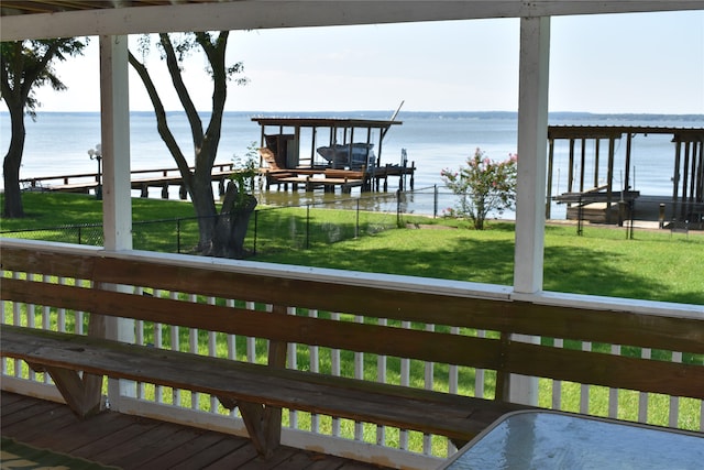 exterior space featuring a dock, a yard, and a water view