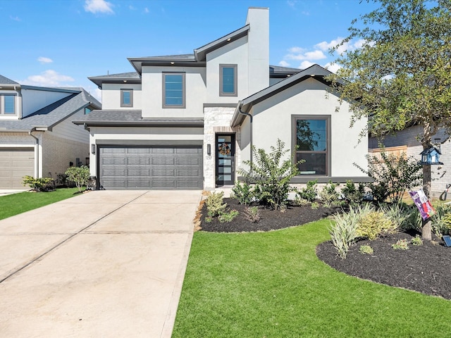 view of front facade with a front yard, an attached garage, driveway, and stucco siding