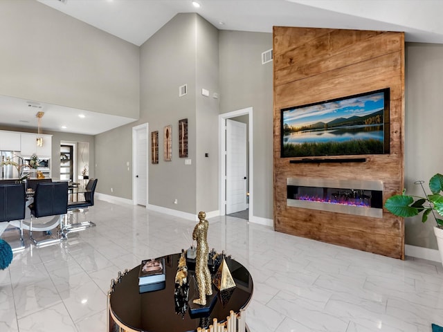 living room with a fireplace and a high ceiling