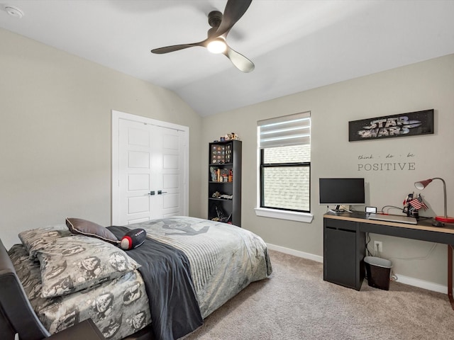 carpeted bedroom with a closet, vaulted ceiling, and ceiling fan