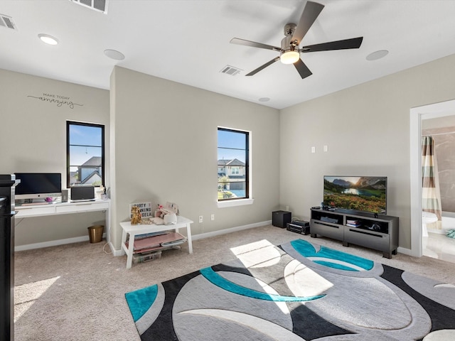 carpeted living room with ceiling fan