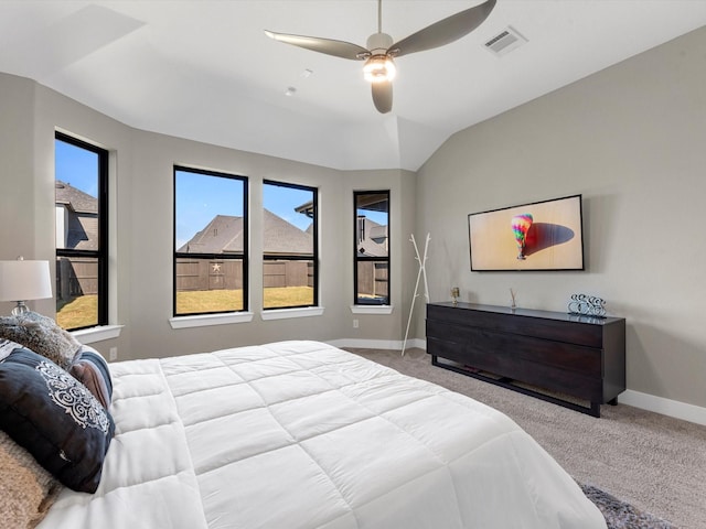 carpeted bedroom with multiple windows, ceiling fan, and vaulted ceiling