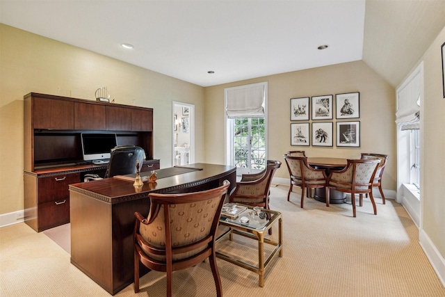 carpeted office with lofted ceiling