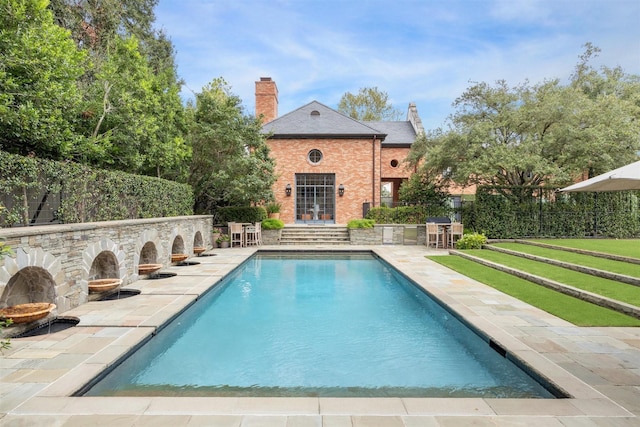 view of pool featuring a patio and an outdoor stone fireplace