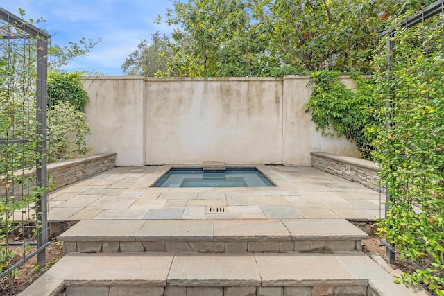 view of patio / terrace featuring an in ground hot tub