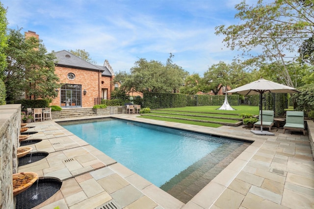 view of swimming pool with a lawn and a patio