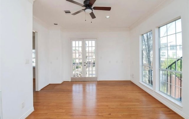 unfurnished room with light wood-type flooring, french doors, a healthy amount of sunlight, and ceiling fan