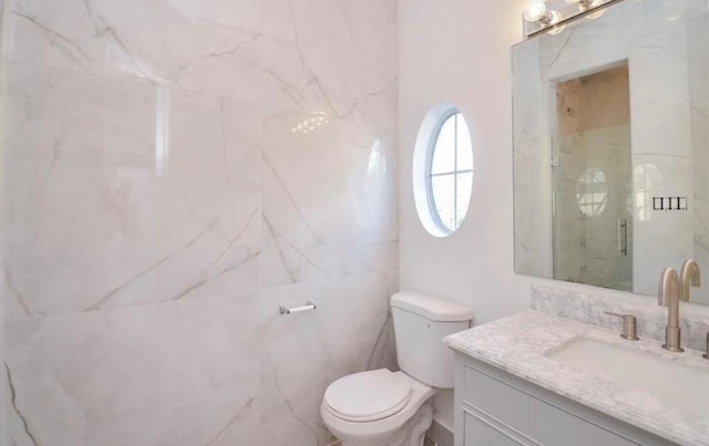 bathroom with vanity, toilet, and a shower with door