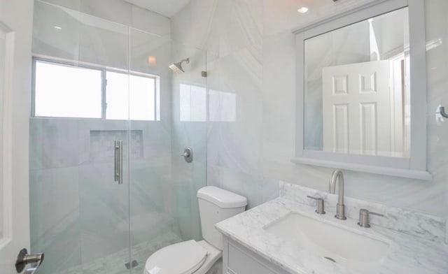 bathroom featuring walk in shower, toilet, and vanity