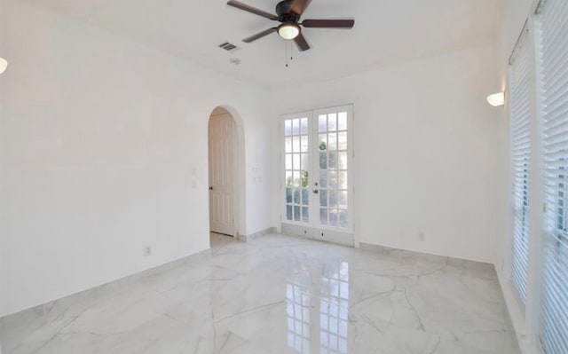 empty room with ceiling fan and french doors