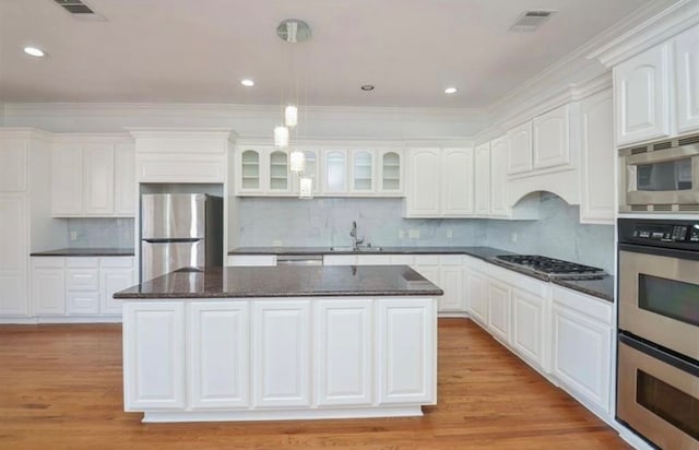 kitchen featuring a kitchen island, appliances with stainless steel finishes, white cabinets, and light hardwood / wood-style floors